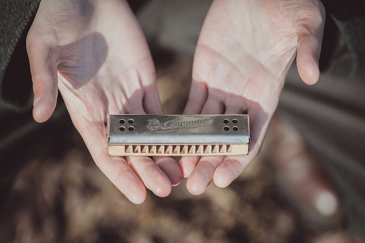 Man holding a beginner-friendly harmonica.
