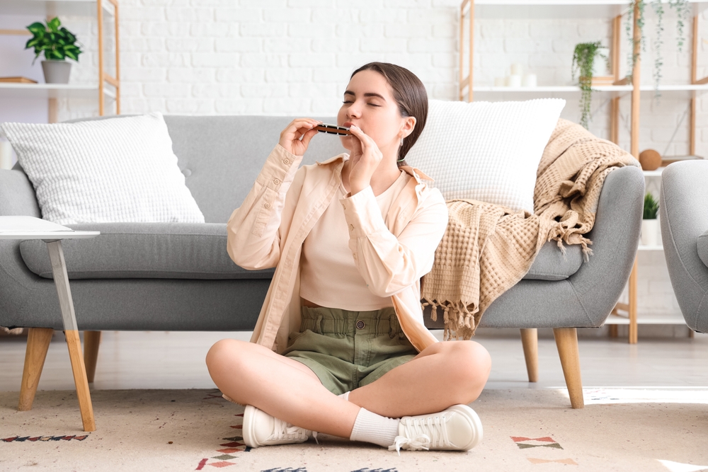 A young woman learning how to bend with a harmonica.