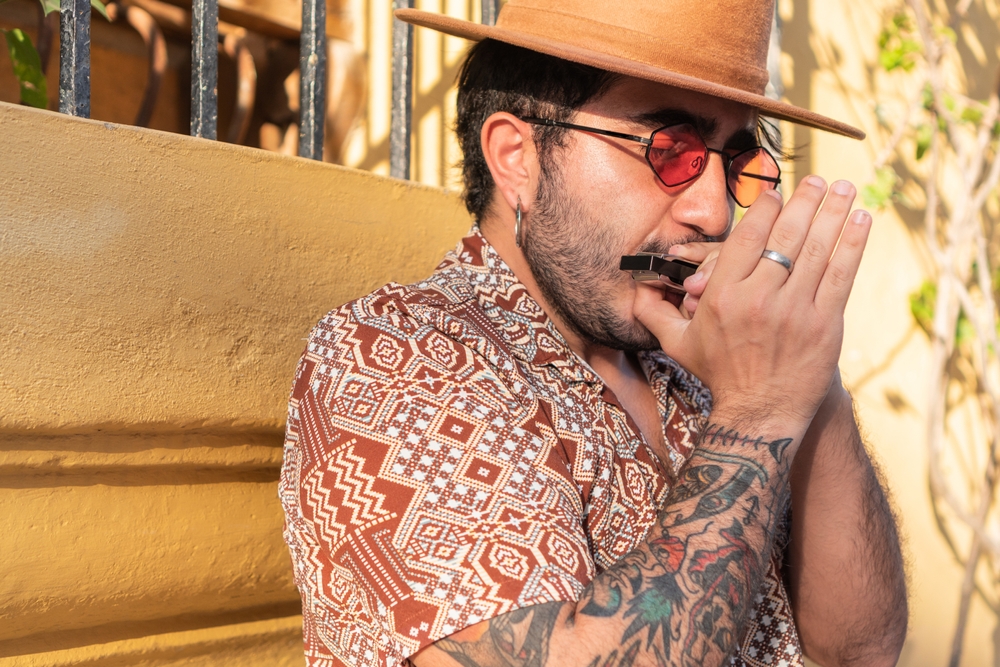 A man practicing his advanced harmonica techniques.