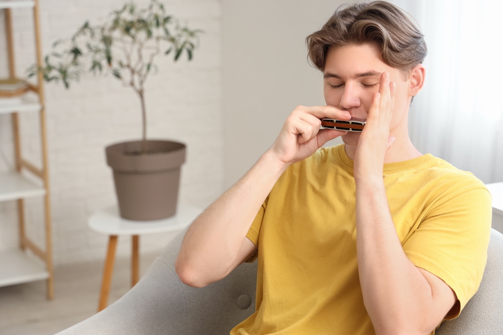 A man working on harmonica techniques.